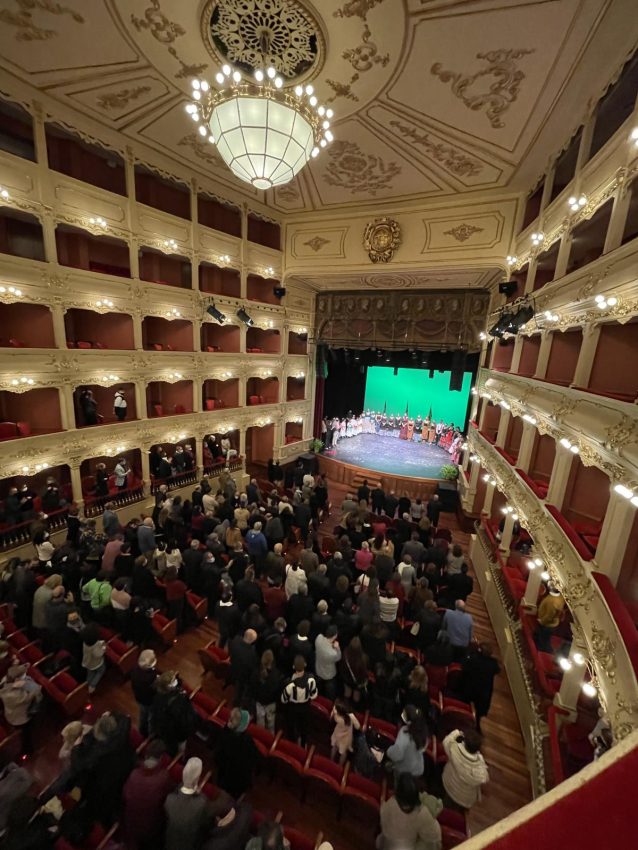 Interior de un teatro en Mahón con público y artistas en el escenario