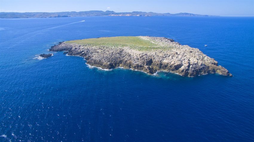 Illa des Porros de Cavalleria, un islote rocoso rodeado de mar azul en el norte de Menorca