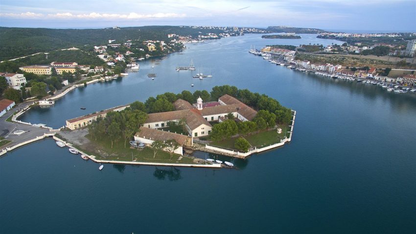 Isla Pinto con sus muelles y edificios navales en el puerto de Mahón, Menorca