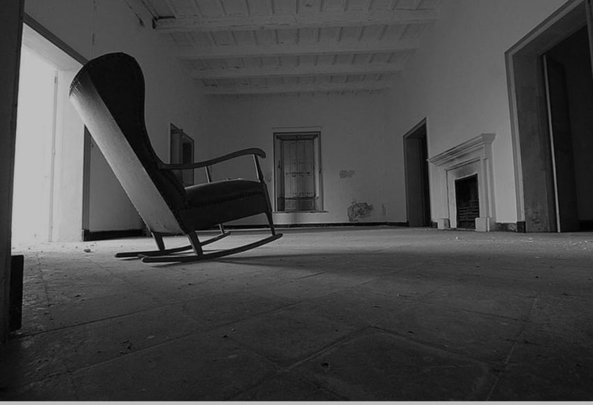 Mecedora en una habitación antigua con chimenea, en blanco y negro