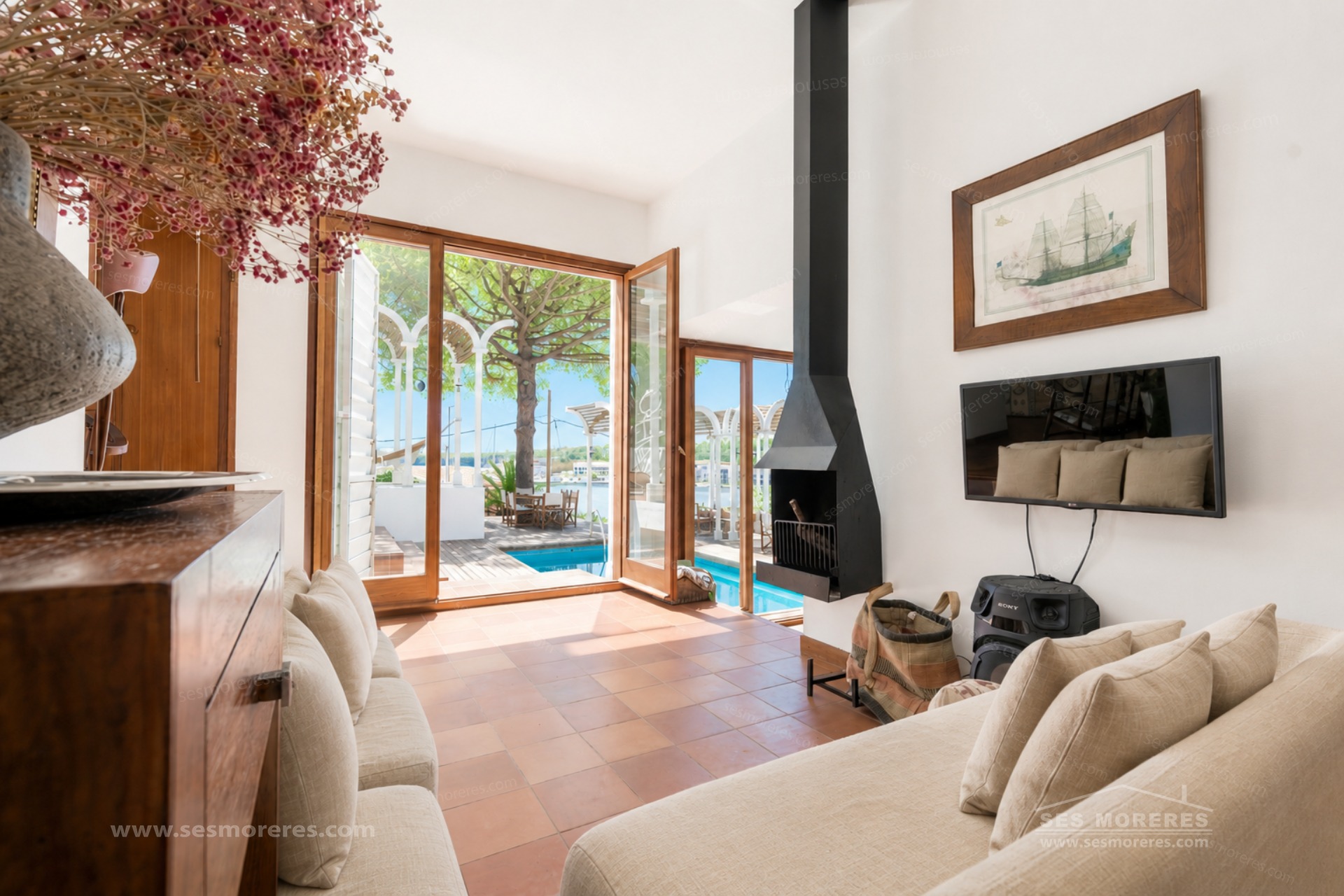 Salon avec cheminée et portes en bois ouvertes sur une terrasse à Mahón