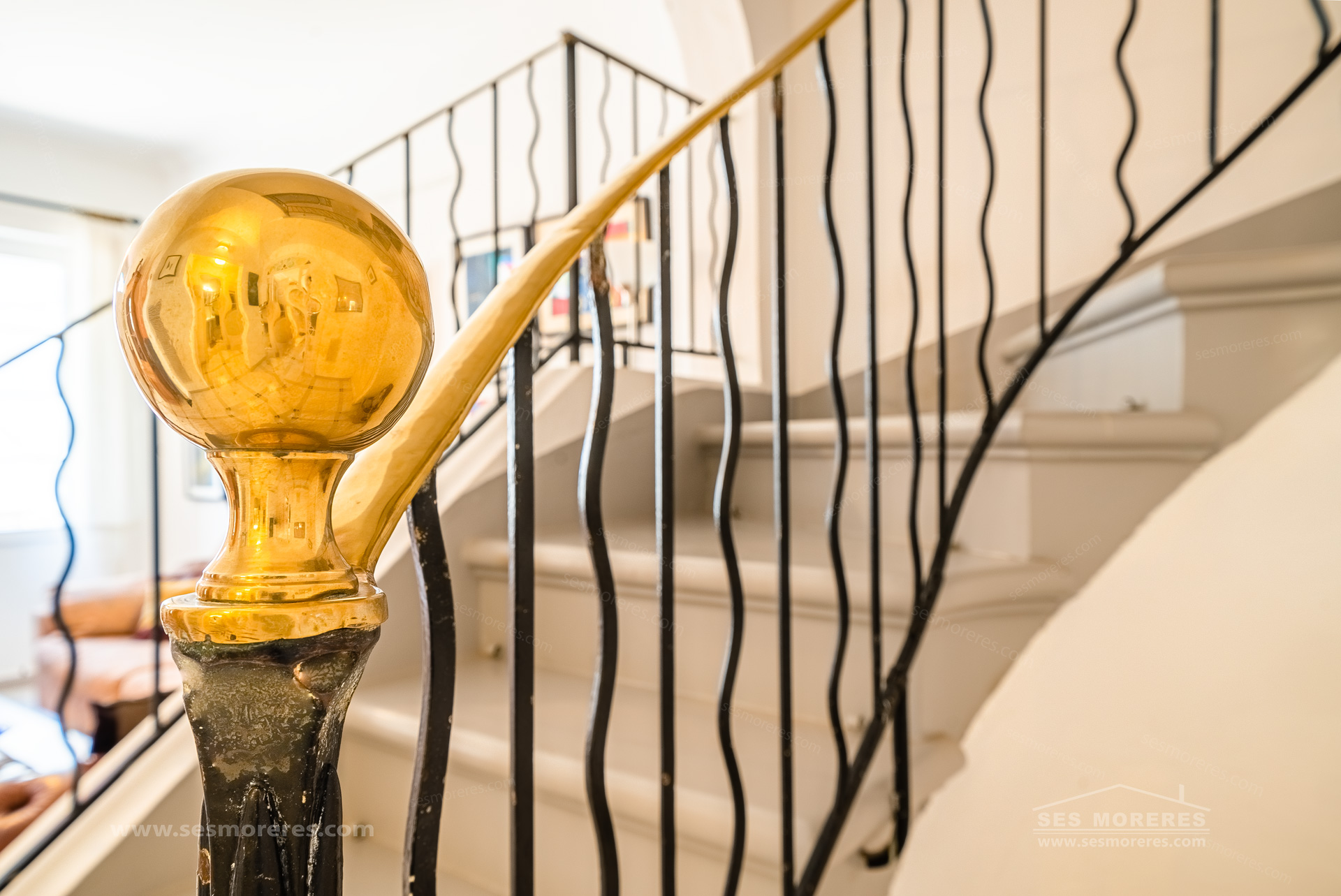 Détail décoratif du départ de la rampe d’un escalier dans une maison à Es Mercadal